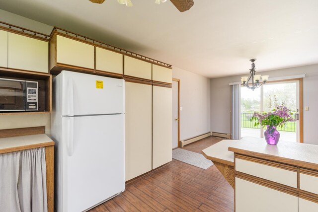 3449 E Cleveland St, Ladd, IL 61329 - kitchen featuring wood finished floors, a baseboard heating unit, freestanding refrigerator, light countertops, and hanging light fixtures