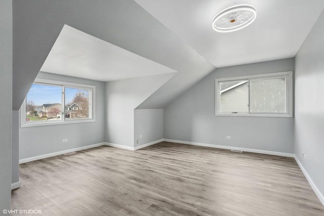 bonus room with lofted ceiling, baseboards, and wood finished floors