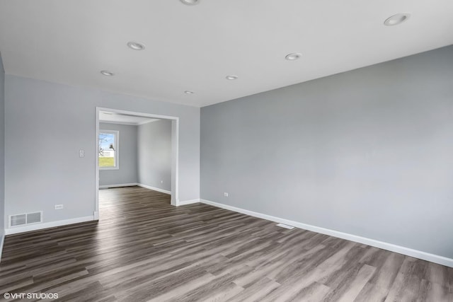 spare room with recessed lighting, visible vents, dark wood-style flooring, and baseboards