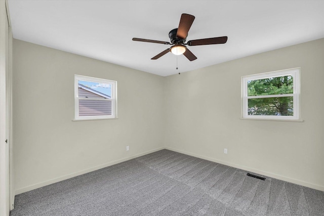 empty room with plenty of natural light, carpet flooring, baseboards, and ceiling fan