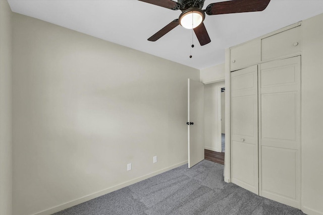 unfurnished bedroom featuring carpet floors, a closet, baseboards, and ceiling fan