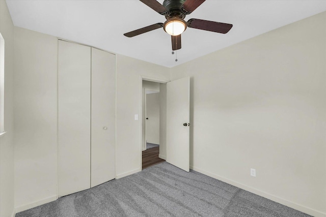 unfurnished bedroom with carpet, a closet, a ceiling fan, and baseboards