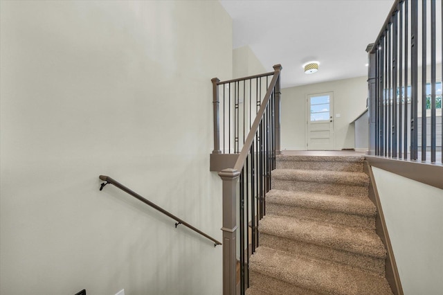 stairs featuring baseboards and carpet floors
