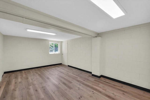 unfurnished room with hardwood / wood-style floors and concrete block wall