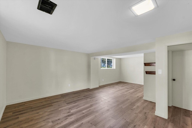 additional living space featuring baseboards, wood finished floors, and visible vents