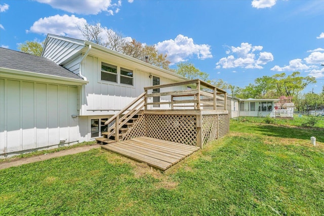 back of property featuring stairs, fence, a yard, board and batten siding, and a wooden deck