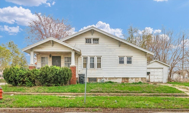 view of front of home featuring a front lawn, driveway, an outbuilding, and a detached garage