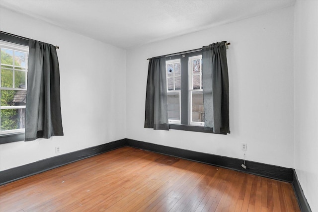 empty room with hardwood / wood-style flooring and baseboards