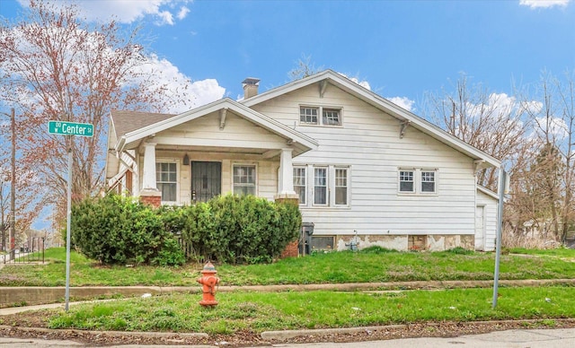 bungalow-style house with a front lawn and a chimney