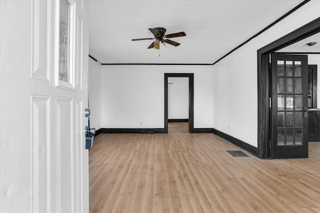 spare room featuring ceiling fan, baseboards, wood finished floors, and visible vents
