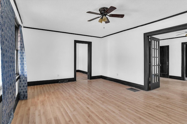unfurnished room with a textured ceiling, visible vents, baseboards, wood finished floors, and ceiling fan
