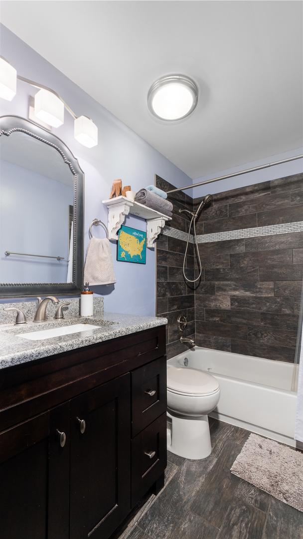 1760 W Wrightwood Ave Unit 305, Chicago, IL 60614 - full bath featuring toilet, wood finished floors, vanity, and bathing tub / shower combination
