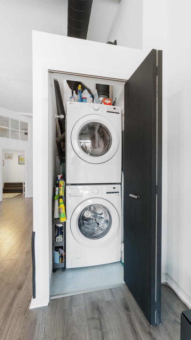 1760 W Wrightwood Ave Unit 305, Chicago, IL 60614 - laundry room featuring laundry area, stacked washer and dryer, and wood finished floors