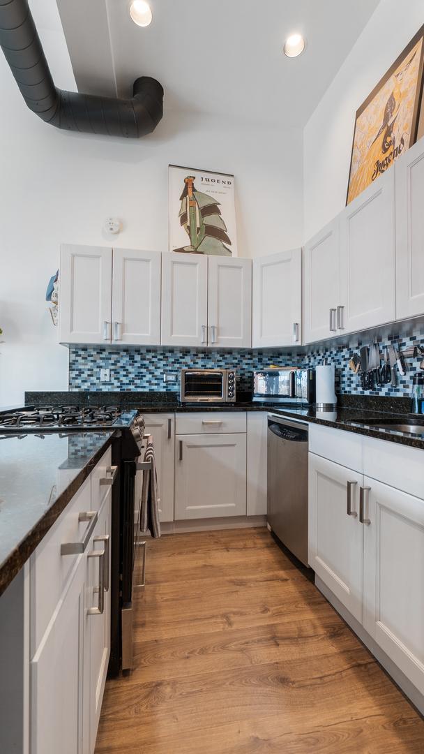 1760 W Wrightwood Ave Unit 305, Chicago, IL 60614 - kitchen featuring tasteful backsplash, appliances with stainless steel finishes, and white cabinetry