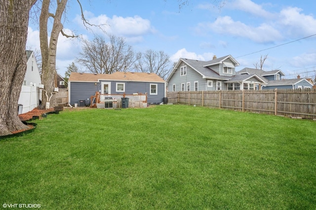 28 S Illinois Ave, Villa Park, IL 60181 - back of house featuring central air condition unit, a fenced backyard, a wooden deck, and a lawn