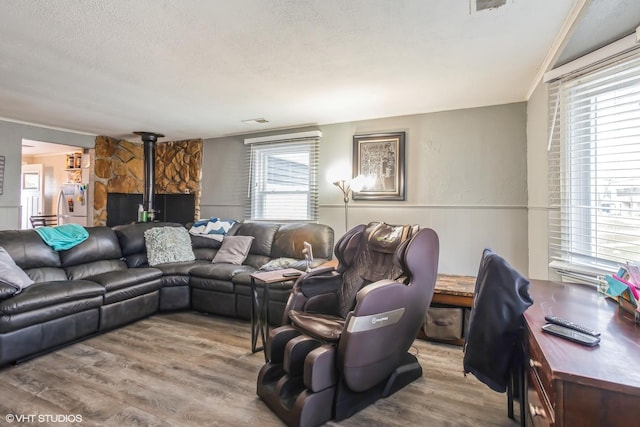 28 S Illinois Ave, Villa Park, IL 60181 - living room featuring visible vents, a wood stove, a textured ceiling, wood finished floors, and a wainscoted wall