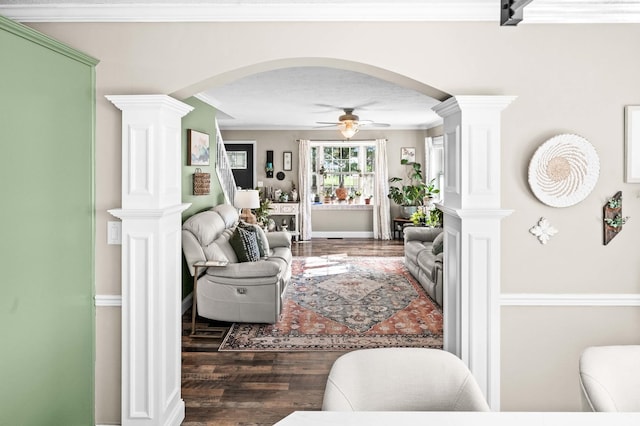 living room with arched walkways, a ceiling fan, wood finished floors, and ornate columns