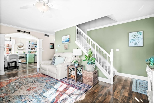 living area with wood finished floors, arched walkways, ornate columns, and crown molding