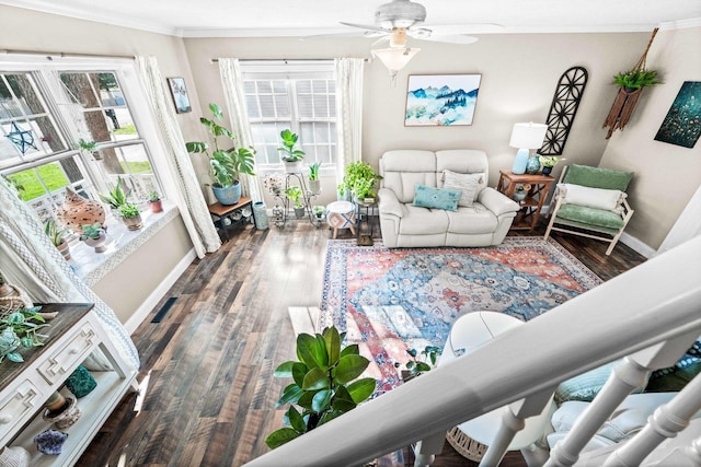 living room featuring wood finished floors, a ceiling fan, baseboards, and ornamental molding