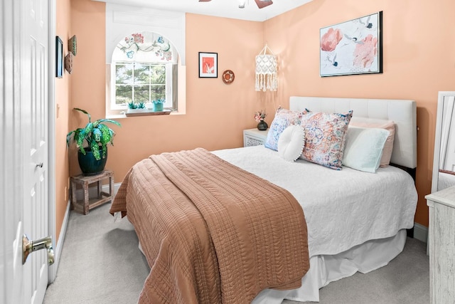 carpeted bedroom with ceiling fan and baseboards
