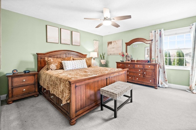 bedroom featuring ceiling fan, light carpet, and baseboards