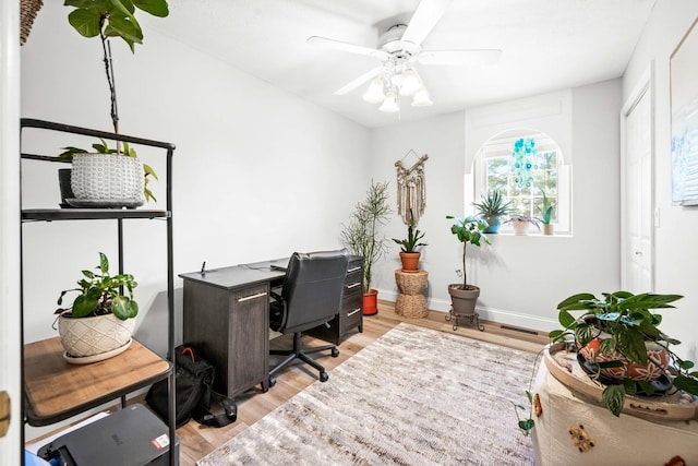 office area featuring light wood-style flooring, baseboards, and a ceiling fan