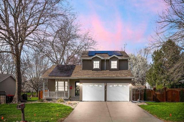 traditional-style house featuring solar panels, a lawn, concrete driveway, and covered porch