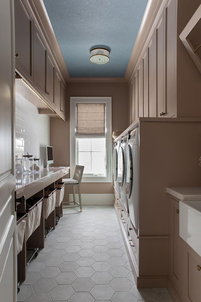 laundry room featuring separate washer and dryer, a textured ceiling, crown molding, and cabinet space