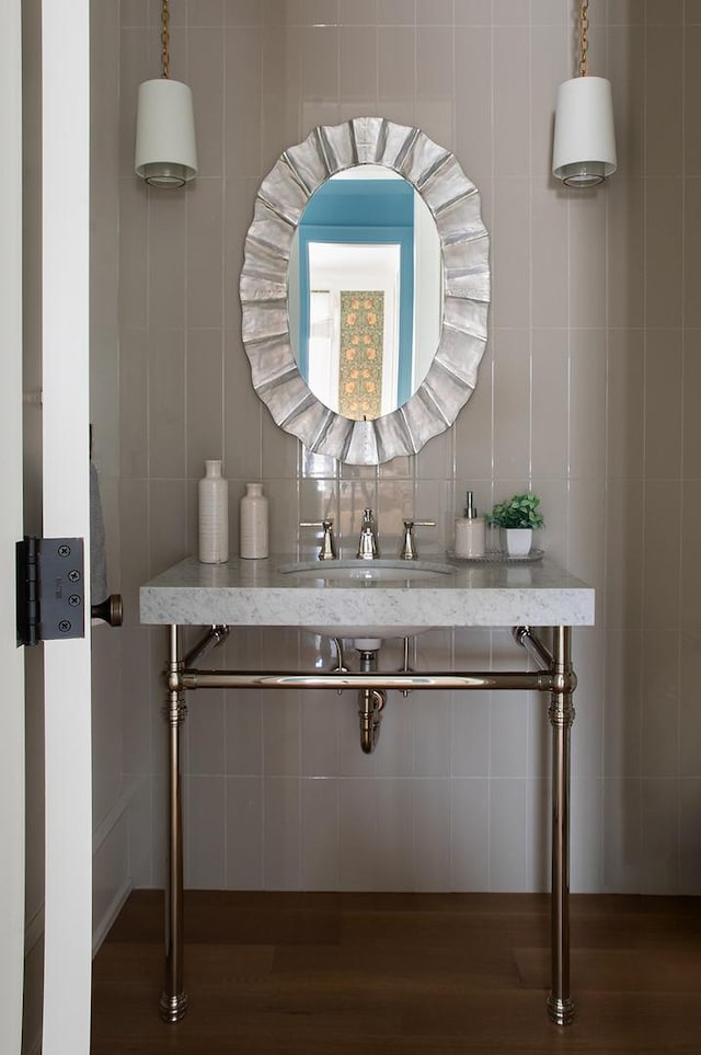 interior details featuring wood finished floors, a sink, and decorative backsplash