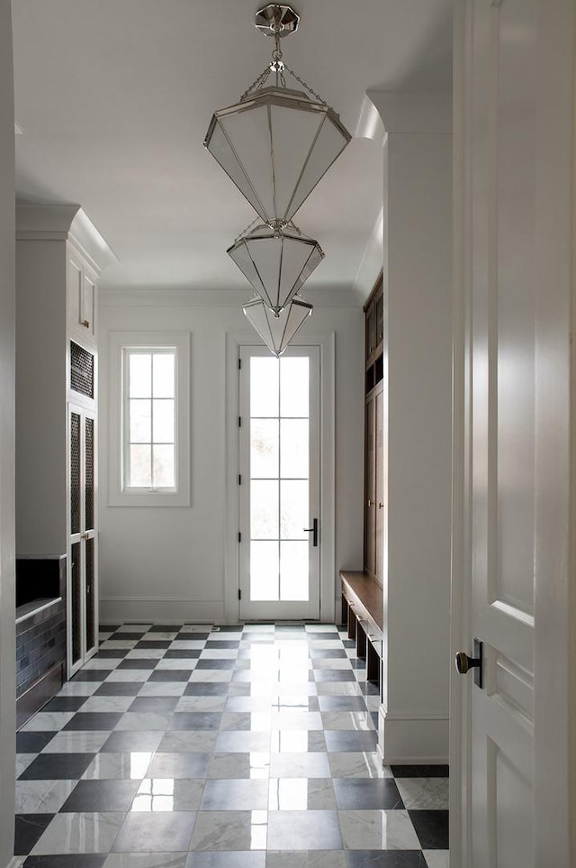mudroom with crown molding and an inviting chandelier