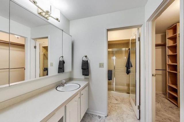 bathroom featuring a shower stall, vanity, and a spacious closet