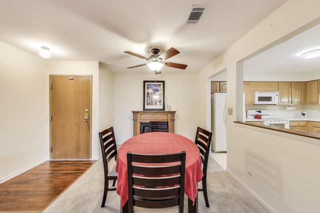 dining room with a fireplace, visible vents, baseboards, and a ceiling fan