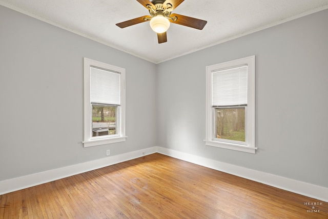 unfurnished room featuring light wood-type flooring, crown molding, a ceiling fan, and baseboards