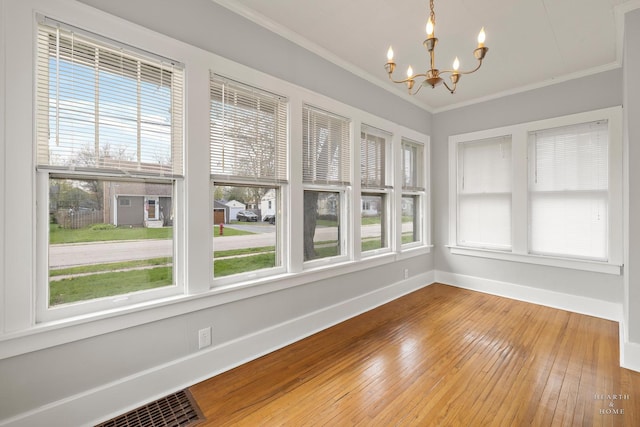 unfurnished sunroom with an inviting chandelier and visible vents