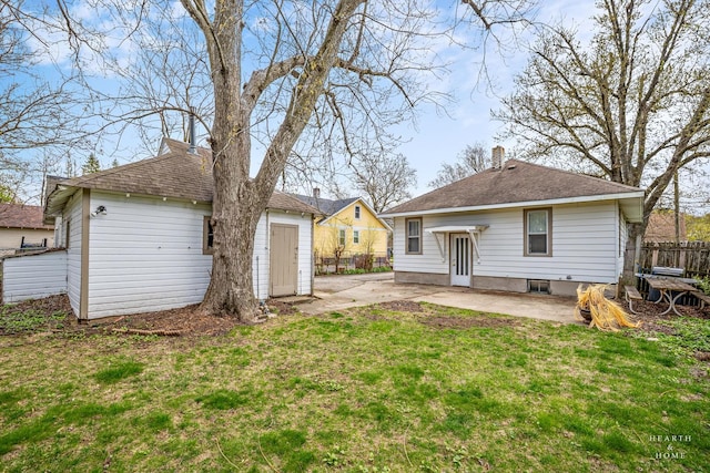 rear view of house with a chimney, fence, a yard, and a patio area