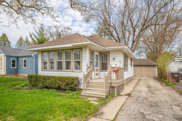 bungalow-style house featuring a detached garage and a front lawn