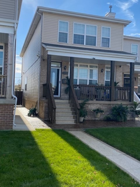 view of front of property featuring covered porch, brick siding, and a front yard