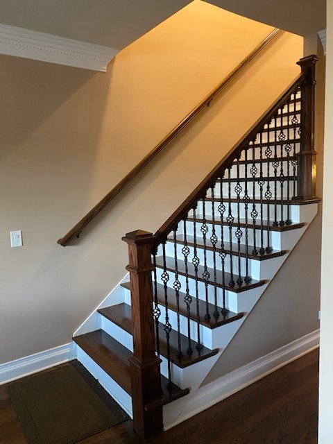 stairway with wood finished floors and baseboards