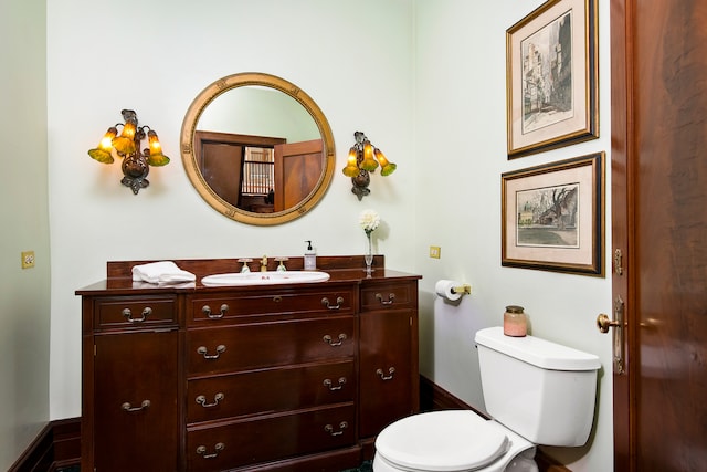 half bath featuring vanity and toilet