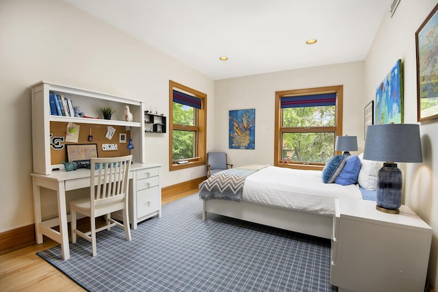 bedroom with wood finished floors, baseboards, and recessed lighting