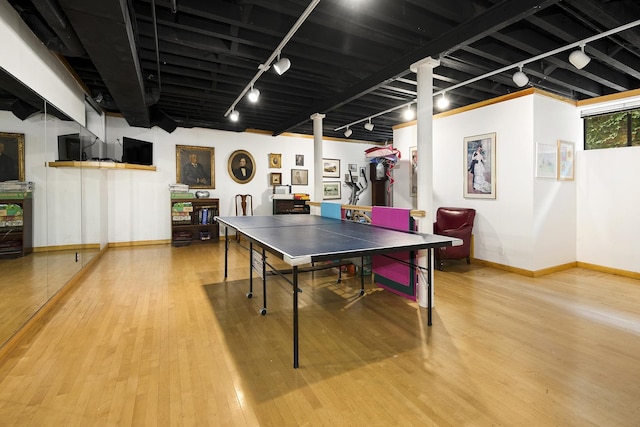 rec room with baseboards, rail lighting, and wood finished floors