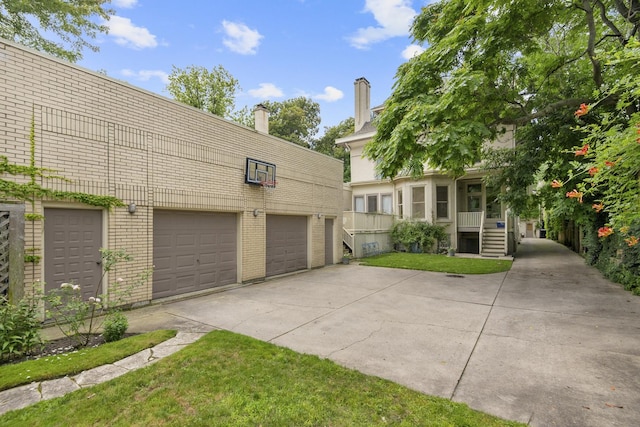 view of front of house with a garage, brick siding, and a chimney