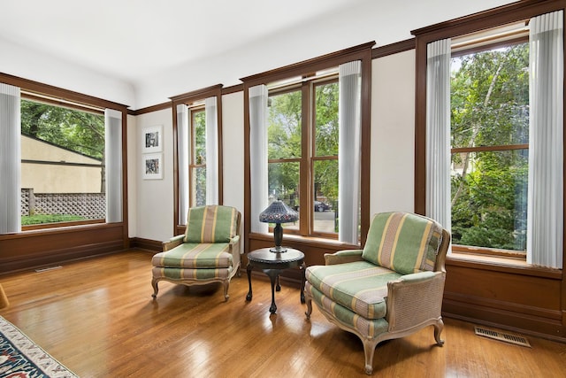 sitting room featuring visible vents, hardwood / wood-style flooring, and a healthy amount of sunlight