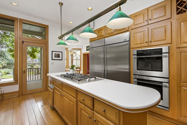 kitchen featuring recessed lighting, light countertops, a kitchen island, light wood-style floors, and stainless steel appliances