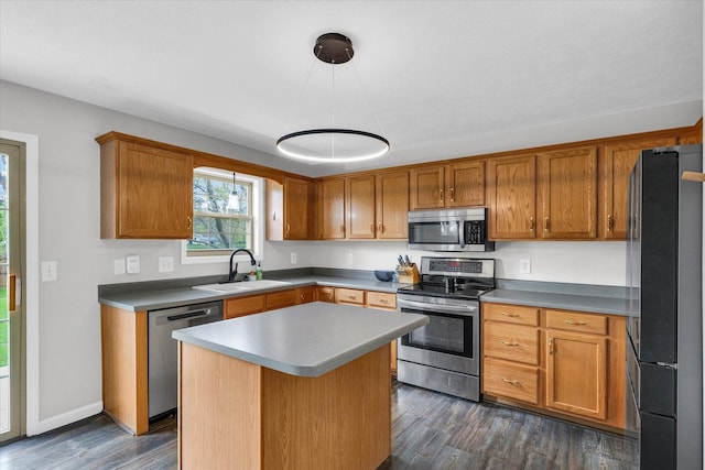 3410 Waterville Ct, Champaign, IL 61822 - kitchen featuring a center island, dark wood-style floors, a sink, brown cabinetry, and appliances with stainless steel finishes