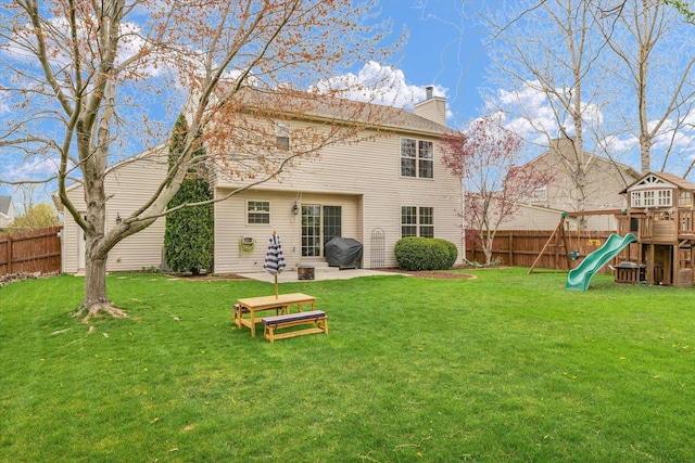 3410 Waterville Ct, Champaign, IL 61822 - back of house with a chimney, a playground, a fenced backyard, a yard, and a patio area