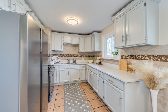 16112 Turner Ave, Markham, IL 60428 - kitchen with light tile patterned floors, a sink, light countertops, freestanding refrigerator, and black range with gas stovetop