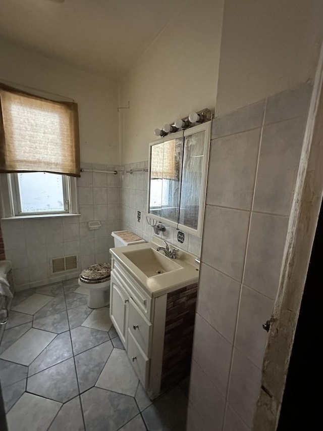 8444 S Essex Ave, Chicago, IL 60617 - bathroom with visible vents, toilet, tile walls, vanity, and tile patterned floors