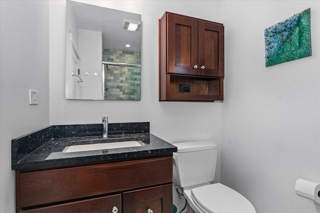 bathroom with vanity, toilet, a stall shower, and visible vents