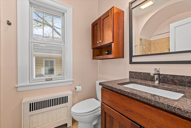full bath featuring radiator, toilet, vanity, and a shower